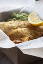 Fish and chips takeaway with mush peas and lemon. Biodegradable eco friendly takeaway cardboard box Royalty Free Stock Photo