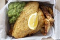 Fish and chips takeaway with mush peas and lemon. Biodegradable eco friendly takeaway cardboard box Royalty Free Stock Photo