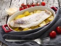 Fish cod baked in the oven with potatoes, diet healthy food. Dark old wooden rustic gray background, side view Royalty Free Stock Photo