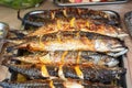 Fish cooked on fire on a plate with leaves parsley and lemon.