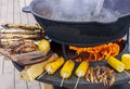 Fish, crayfish and corn are grilled on a round grill Royalty Free Stock Photo