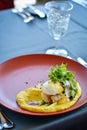 Fish dish with puree on red plate in restaurant. Royalty Free Stock Photo