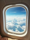 airplane window view to a blue cloudy sky