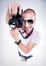 Fish eye shot of funny photographer posing with a camera smiling Royalty Free Stock Photo