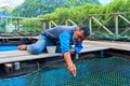 Fish farm excursion. Man feeding stingray close up