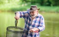 Fish farming pisciculture raising fish commercially. Fisherman alone stand in river water. Man senior bearded fisherman