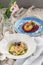 Fish fillet with zucchini and fish rissole with beet on the table Royalty Free Stock Photo