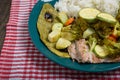 Fish fillets, vegetables and cactus (nopal) baked with white rice on a wooden table.