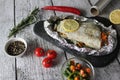 Fish in foil on a stone baked with lemon and vegetables Royalty Free Stock Photo