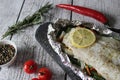 Fish in foil on a stone baked with lemon and vegetables Royalty Free Stock Photo