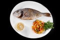 Fish grill dish baked whole grilled on a plate with vegetables and lemon on top for the menu Royalty Free Stock Photo