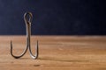 Fish Hook on a wooden surface with dark background Royalty Free Stock Photo