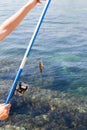 Fish hooked on a hook against the sea Royalty Free Stock Photo