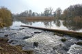 Fish ladder with steps made of natural stones and wild water at the mill pond of Rehna on an overcast winter day, Mecklenburg-