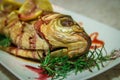 Fish with lemon wedges and a green rosemary. Shallow depth of field.