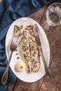 Fish mackerel baked with herbs, mashed potatoes, pesto sauce served on a white plate on a wooden antique background, next to a bl Royalty Free Stock Photo