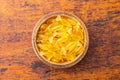 Fish oil capsules in bowl. Yellow omega 3 pills on wooden table