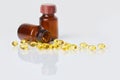 Fish oil capsules in dark glass bottle on white  background. Royalty Free Stock Photo