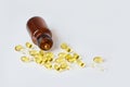 Fish oil capsules in dark glass bottle on white  background. Royalty Free Stock Photo