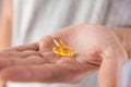 Fish oil capsules with omega 3, vitamin D in male hand. Nutritional supplement, medicine, drug for health care. Royalty Free Stock Photo