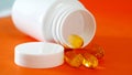 Fish oil capsules. Yellow omega 3 pills in white plastic bottle