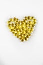 Fish oil from cod liver in capsules for children and adults in the form of a heart with a block of tablets on a white background, Royalty Free Stock Photo