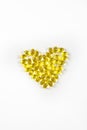 Fish oil from cod liver in capsules for children and adults in the form of a heart on a white background, prevention, vertical Royalty Free Stock Photo