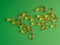 Fish oil omega 3 capsules on green background Royalty Free Stock Photo