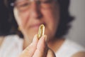 Fish oil pill in old woman`s hand Royalty Free Stock Photo