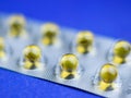 Fish oil pills in a blister on a blue table. Selective focus. Royalty Free Stock Photo