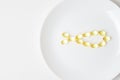 Fish oil softgels on a white plate in a shape of a fish. Meal replacement. Nutrition prescription. Omega-3 polyunsaturated fatty