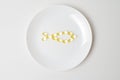 Fish oil softgels on a white plate in a shape of a fish. Meal replacement. Nutrition prescription. Omega-3 polyunsaturated fatty