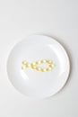 Fish oil softgels on a white plate in a shape of a fish. Meal replacement. Omega-3 polyunsaturated fatty acids on a plate. Casual