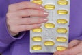 Fish oil for womens health.omega fatty acids. Fish oil capsules in blisters in hands .Dietary supplements and vitamins