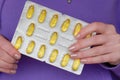 Fish oil for womens health.omega fatty acids. Fish oil capsules in blisters in hands .Dietary supplements and vitamins