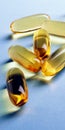 Fish oil. Yellow softgels lie on a light blue surface. Healthy lifestyle. Vertical illustration. Softgel closeup. Omega-3 fatty