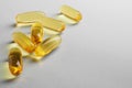 Fish oil. Yellow softgels lie on a white or light gray surface. Vitamins and a healthy lifestyle. Background or backdrop. Copy Royalty Free Stock Photo