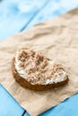 Fish pate spread on a slice of bread on the wrinkled brown paper