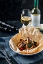 Fish pies and vegetables in craft paper on plate, restaurant giving. Style rustic. Selective focus.