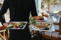 Waiter is holding plates with ready-made dishes in his hands Royalty Free Stock Photo