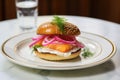 fish sandwich with pickled onions on porcelain plate