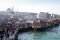 Fish sandwich shop boats in Eminonu Pier at to mouth of the Golden Horn Bay. Crowd of people outside in Eminonu Square, Istanbul, Royalty Free Stock Photo