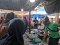 fish seller serving customers in traditional market