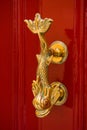 Fish shaped golden knocker on a red wooden door Royalty Free Stock Photo