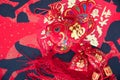 Fish-shaped ornaments and red envelopes on red spring couplets background.The Chinese characters on the spring couplets mean `happ