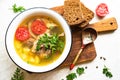 Fish soup with carp, potatoes, parsley, tomato in enamel bowl stands on a board Royalty Free Stock Photo