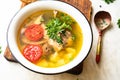 Fish soup with carp, potatoes, parsley, tomato in enamel bowl stands on a board Royalty Free Stock Photo