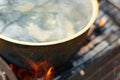 Fish soup with grayling cooked in large castiron pot at bonfire