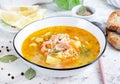 Fish soup with salmon, vegetables and rice in white bowl.