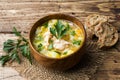 Fish soup in a wooden bowl with fresh herbs